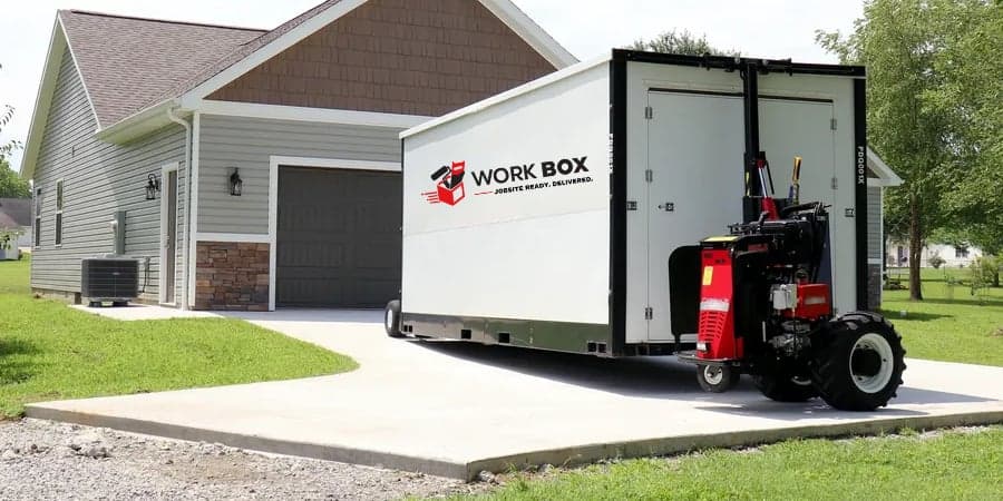 A WorkBOX unit being set down on a residential driveway beside a garage